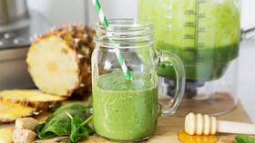 Svež zelen zelenjavni smoothie v steklenem kozarcu s slamico