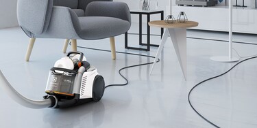 Nekdo uporablja izredno dolg kabel Electroluxovega sesalnika UltraFlex AnimalCare za preprosto sesanje dnevne sobe