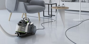 Nekdo uporablja izredno dolg kabel sesalnika Electrolux UltraFlex Green za preprosto sesanje dnevne sobe